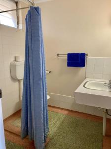 a bathroom with a blue shower curtain and a sink at Minnipa Hotel in Minnipa