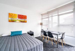 sypialnia z łóżkiem, stołem i krzesłami w obiekcie City West Motel w mieście Adelaide