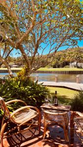 a table and two chairs and a bottle of wine at Beachside Resort Lagoon Rooms with Garden Patio in Coffs Harbour