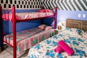 a bedroom with two bunk beds with pink sheets at Pousada Cachoeira da Fumaça in Palmeiras