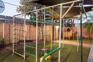 a playground with a swing set and a tree at Red Sands Accommodation Newman in Newman