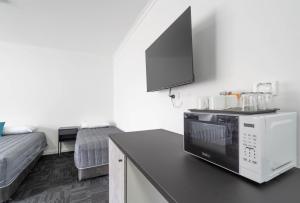 a kitchen with a microwave on top of a counter at City West Motel in Adelaide