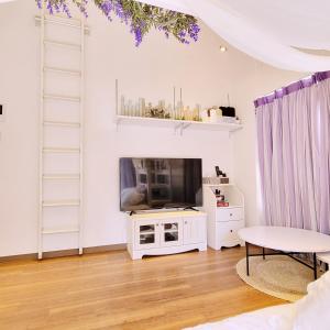 un soggiorno con TV e scaffali bianchi di Jellynehouse新大久保 a Tokyo