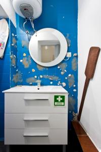 ein Badezimmer mit einem weißen Waschbecken und einem Spiegel in der Unterkunft Oporto Blue Lapa - Original Citycenter House! in Porto