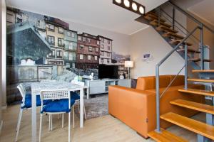 a living room with a table and chairs and a staircase at Oporto Blue Lapa - Original Citycenter House! in Porto