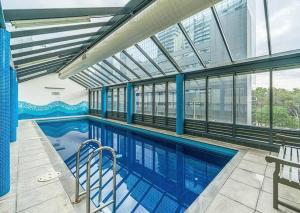 ein Pool in einem Gebäude mit großen Fenstern in der Unterkunft City skyline views with swimming pool! in Melbourne