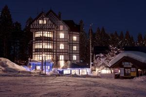 a large building is lit up in the snow at night at Hakuba Sun Valley Hotel Annex in Hakuba