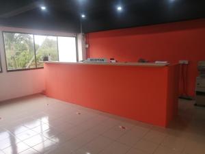 an office with an orange wall and a counter at Sri Sayang Resort Service Apartment in Batu Ferringhi