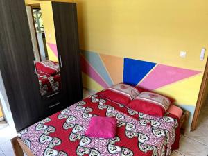 een slaapkamer met een bed met een kleurrijke muur bij Le nid des aigles in Sainte-Rose