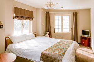 a bedroom with a large white bed and two windows at Hakuba Sun Valley Hotel Annex in Hakuba
