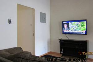 ブリッジタウンにあるCozy, quiet 1 bedroom 2A near Beach near US Embassyのソファと薄型テレビのあるリビングルーム