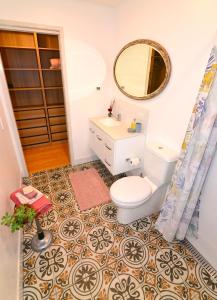 a bathroom with a toilet and a sink and a mirror at Studio with Rural views in Goonellabah