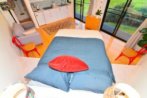 a small bedroom with a bed with a red pillow at Studio with Rural views in Goonellabah