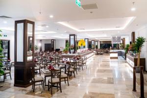 a restaurant with tables and chairs in a room at Ha Long Dream Hotel in Ha Long