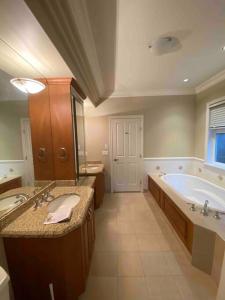a large bathroom with a tub and a sink at Lucky suite, two-bedroom suite in Richmond close to YVR in Richmond