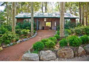 una pequeña casa en medio de un bosque en Discovery Parks - Narooma Beach, en Narooma