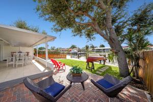 un patio con sillas, una mesa y un árbol en Dania Beach Waterfront,near Hollywood & Fll, en Dania Beach