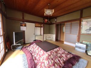 een slaapkamer met een bed in het midden van een kamer bij ゲストハウス陽だまりの宿 in Tomi