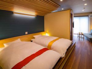 指宿的住宿－海老莊酒店，一间带两张床和一张沙发的卧室