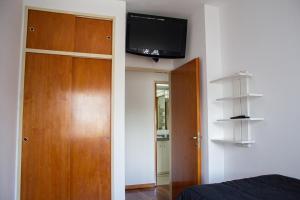 1 dormitorio con 1 cama y TV de pantalla plana en la pared en Departamento 3 ambientes con balcón y 2 baños en Buenos Aires