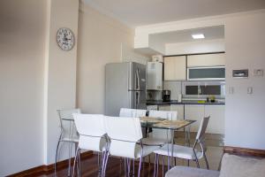 cocina con mesa de comedor y sillas blancas en Departamento 3 ambientes con balcón y 2 baños en Buenos Aires