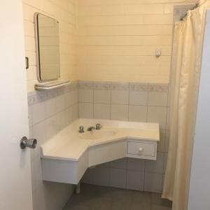 ein Bad mit einem Waschbecken und einem Spiegel in der Unterkunft Minnipa Hotel in Minnipa