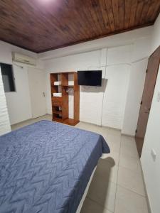 1 dormitorio con 1 cama y TV de pantalla plana en Departamento Duvivier en Resistencia