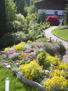 einen Garten mit bunten Blumen und einem Pfad in der Unterkunft Neurauthof in Zellberg