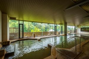 a large pool of water in a building with windows at Fukuichi in Shibukawa