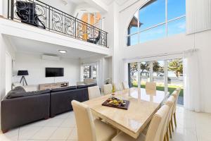 a dining room with a table and a couch at Beachfront Family Favourite Home with Pool & Views in Mandurah