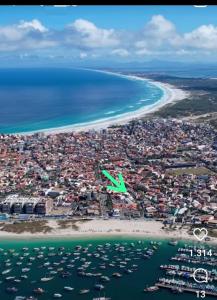 an airplane flying over a beach and the ocean at Suite dos Anjos com Cozinha 150m da Praia in Arraial do Cabo