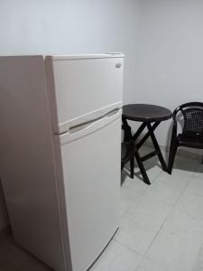 einen Kühlschrank in einer Küche mit einem Tisch und einem Stuhl in der Unterkunft Apartamento independiente para pareja in Villavicencio