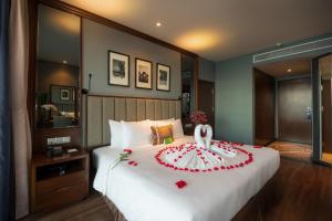 Un dormitorio con una cama grande con un pastel de boda. en Boton Blue Hotel & Spa, en Nha Trang