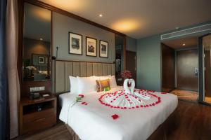 um quarto com uma cama grande e um bolo de casamento em Boton Blue Hotel & Spa em Nha Trang