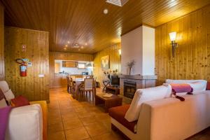 uma sala de estar com sofás brancos e uma sala de jantar em Casa das Arribas - Rio Douro aos seus pés na Bemposta