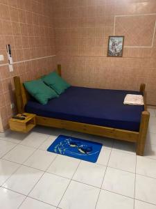 1 dormitorio con 1 cama con sábanas azules y almohadas verdes en Studio « Ti Thon » avec vu magnifique sur la Montagne du Vauclin, en Le Vauclin