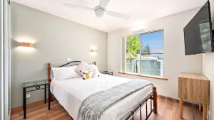 Schlafzimmer mit einem Bett und einem Fenster in der Unterkunft Sunset Sails Taylors Beach NSW in Taylors Beach