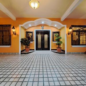 an empty lobby with a door and potted plants at La Mansión del Gran Jaguar in Retalhuleu