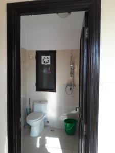 a bathroom with a toilet and a picture of a dog on the wall at Drala Resort Nepal in Kathmandu