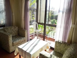 een woonkamer met een tafel en stoelen en een raam bij Drala Resort Nepal in Kathmandu