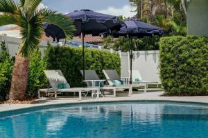 een zwembad met stoelen en parasols naast een zwembad bij PACK YOUR BAGS FOR THE ATLANTIC BEACH HOUSE WHERE YOU CAN HAVE IT ALL ! in Fort Lauderdale