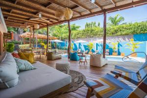 a living room with a couch and chairs and a pool at Hotel Arco Iris in Tamarindo