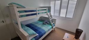 a bunk bed with a ladder in a room at Bay Village - Shoal Bay Apartments in Shoal Bay