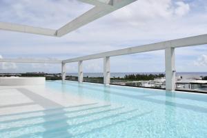 a swimming pool on the roof of a building at Ceren Luxury Apartments at Fifth Avenue by Spot Rentals in Playa del Carmen