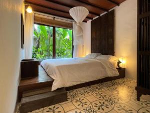 a bedroom with a bed and a large window at Chiang Maan Residence in Chiang Mai