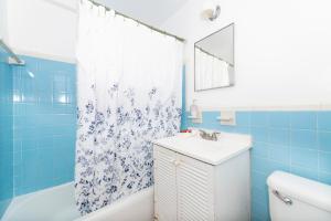 a blue bathroom with a sink and a shower curtain at Tropic Isle Hotel & Apartment in Hollywood +66 photos