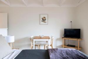 a bedroom with a bed and a table with a television at Nornalup Riverside Chalets in Nornalup