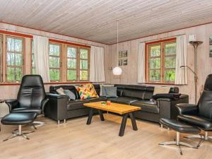uma sala de estar com um sofá, cadeiras e uma mesa em 8 person holiday home in Oksb l em Oksbøl