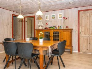 uma sala de jantar com uma mesa de madeira e cadeiras em 8 person holiday home in Oksb l em Oksbøl