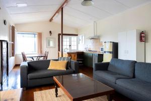 a living room with two couches and a table at Nornalup Riverside Chalets in Nornalup